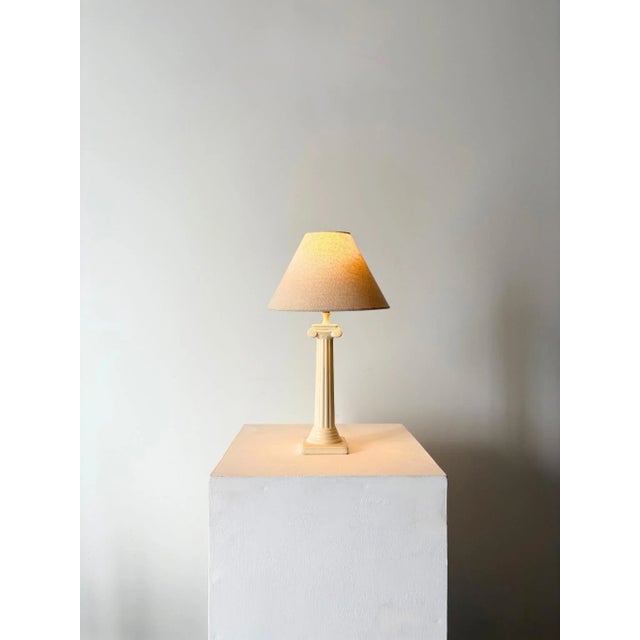 A postmodern lamp in an ionic column design. Emulating a classical architectural column, this accent light has a fluted...