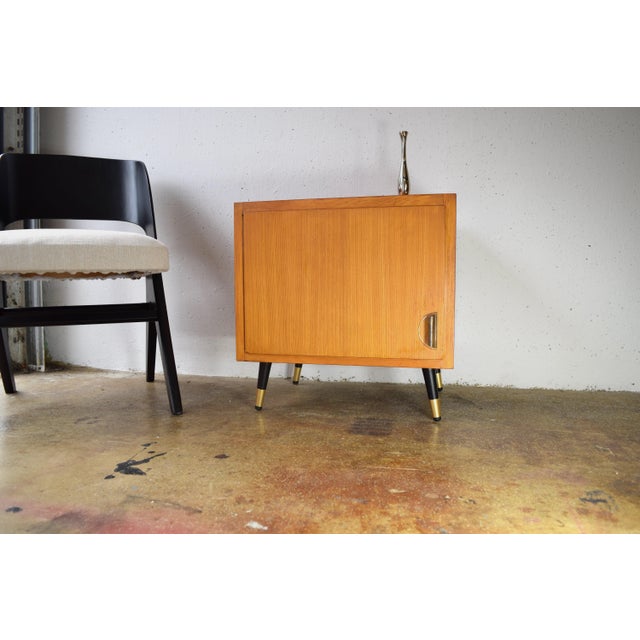 This is a small vintage chest of drawers from the 1950s. The black, tapered metal legs give the cabinet a tapered look....