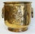 Antique hammered brass cachepot planter with a repousse depiction of a man with cup to two sides and ringed lion head...