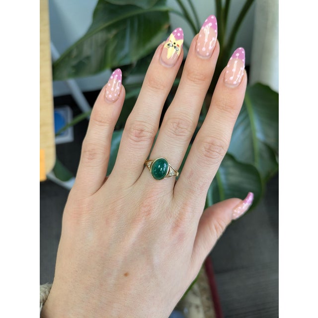 Vibrant 3.7ct Zambian emerald in a classic oval cut, set in solid 14K gold for timeless elegance. Natural diamond accents...