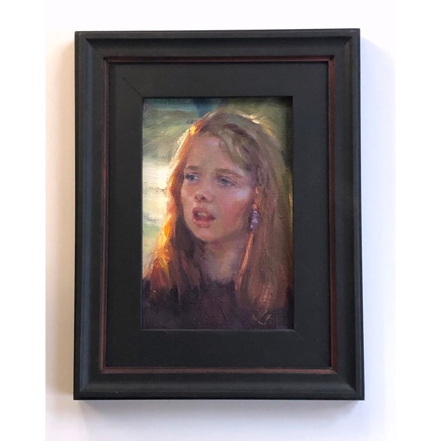 The artwork depicts a young girl with flowing hair, her expression revealing a moment of contemplation or introspection....