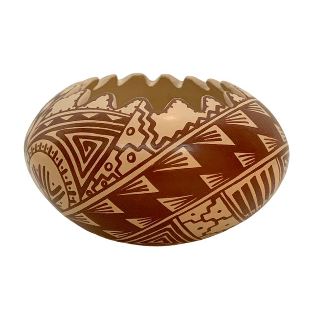 Vintage Southwestern pottery bowl with a hand-painted geometric tribal pattern in warm earth-tone hues of terracotta,...