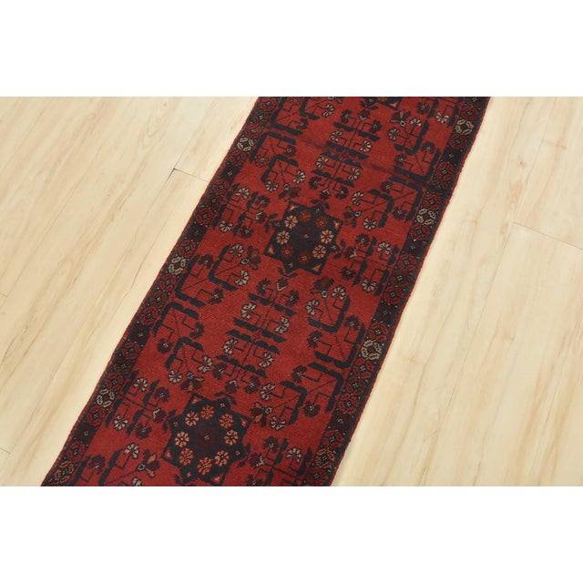 A tribal Turkmen runner hand-knotted with an all-wool pile on a wool foundation. This nomadic oriental rug features...