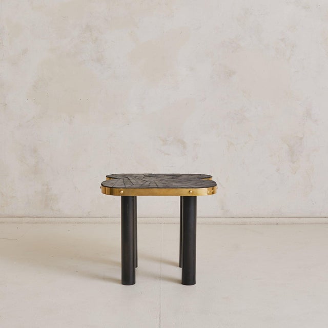 A sculptural 1990s French side table defined by bold material contrast and graphic rhythm. The clover-shaped top is...