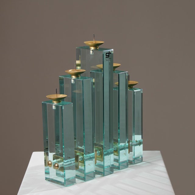 Rare architectural candle holder featuring five solid glass stelae connected by high-quality brass spacers. The design is...