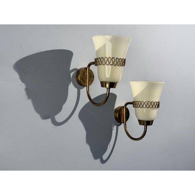 Mauri Almari, Finnish Mid-Century Modern, Wall Lights or Sconces, Brass, Glass, Finland, 1960s Pair of opaline glass and...