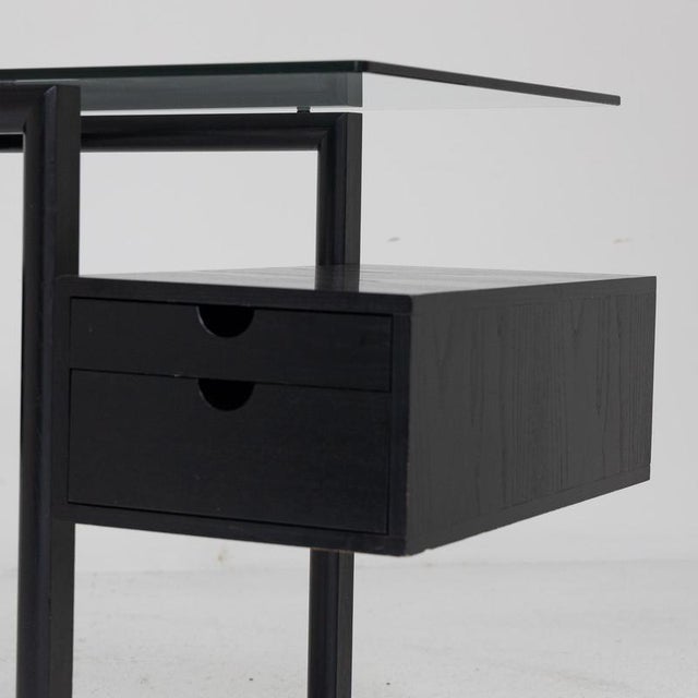 Refined desk from the 1980s made entirely of black lacquered ash wood, with an essential and rigorous design. The...