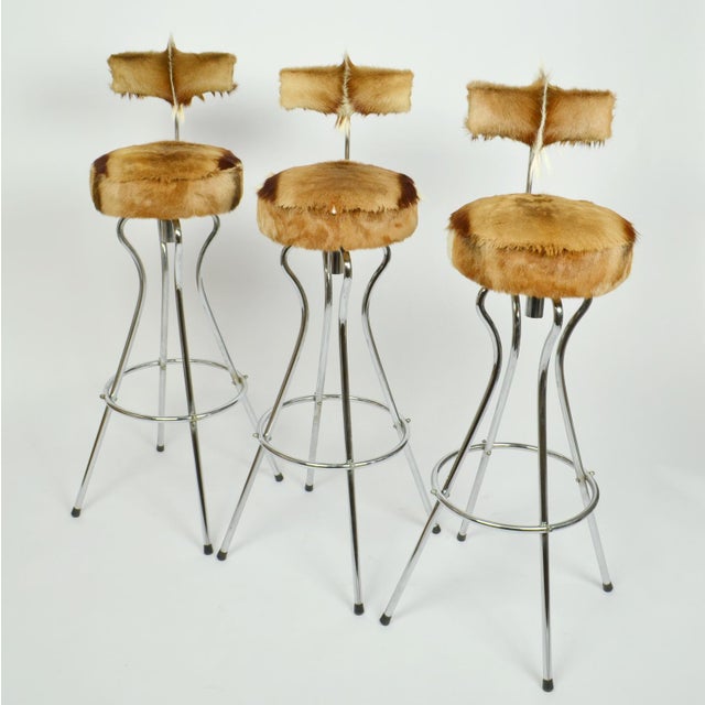 Set of three swivel bar stools with back rest in chrome, new upholstery in goatskin by Tambourin. The way they are...