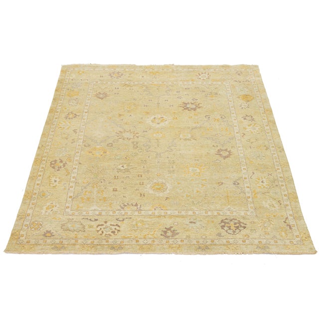 This contemporary Oushak-style wool rug combines modern design with traditional craftsmanship. It has a striking tan...