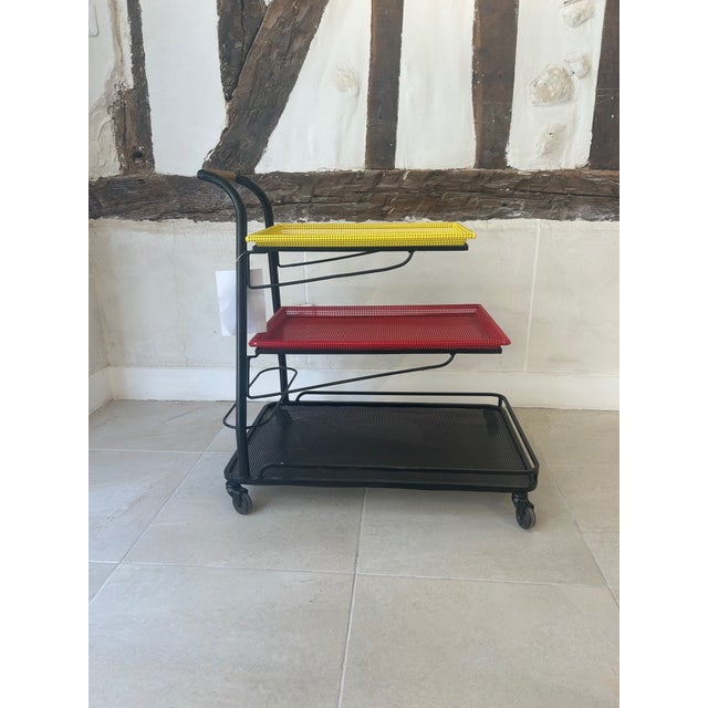 This service trolley is made of perforated sheet metal by Mathieu Matégot. It has three shelves, two of which are...