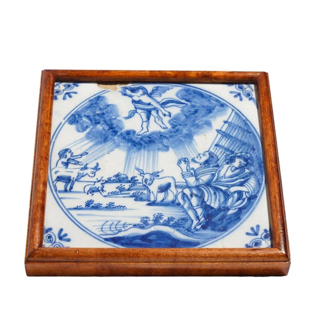 Delft tile depicting of the Annunciation, mounted in a hard wood bead molding. Fitted with a leather backing. Netherlands,...