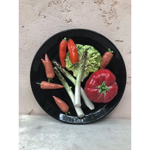 Large French Majolica vegetables wall platter Vallauris, circa 1950. On a black background it's a trompe l'oeil platter...