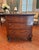 A French Empire three-drawer commode, circa 1810–1830, with tailored rectangular form and paw-foot base. Crafted from...