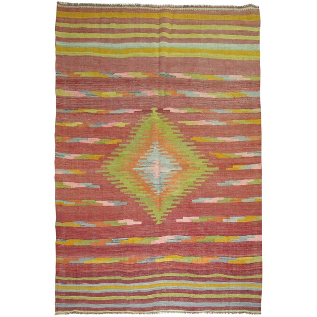 A colorful Turkish Kilim flat-weave rug. Large-scale lime green medallion with accents in orange, pink, gray on a burnt...