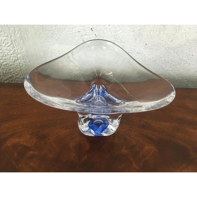 This bowl is simple elegance, the touch of blue and the unusual shape make it unique. We are not able to read the signature