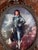 This is a vintage reproduction of Thomas Gainsborough’s “The Blue Boy,” displayed beneath convex glass in an ornate brass-...
