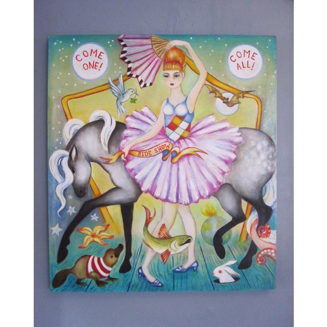 Side Show features a whimsical scene with a central figure dressed in a vibrant ballet costume, surrounded by playful...
