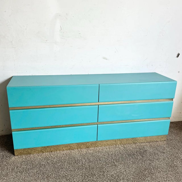 Add a bold statement to your space with this Postmodern Teal Laminate Dresser, featuring six spacious drawers and sleek...