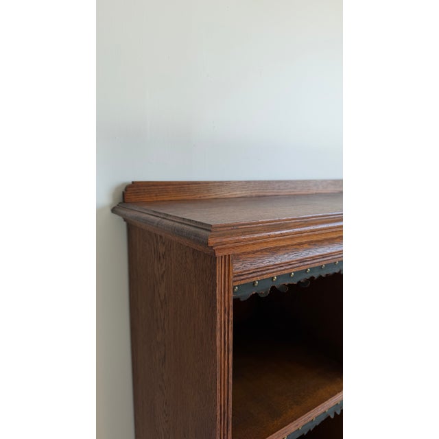 Constructed in oak with a rich, warm patina, the piece features a handsome molded cornice top and a base with a stepped...