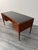 A stunning semi curved writing desk featuring three lockable drawers with brass handles on each side with a deep shelf to...