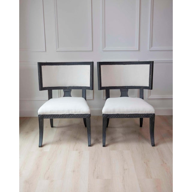 A striking pair of early 19th-century Swedish Empire chairs, defined by their bold architectural silhouettes and...