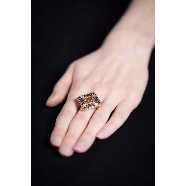 A diamond-shaped signet ring in 18K gold and enamel detailing. It has some open work within the enamel geometric center to...