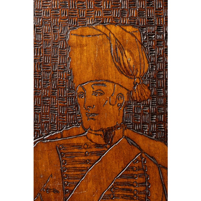 Antique notch-carved medicine cabinet featuring a detailed carving of a bugler on the front and a woman on horseback on...