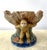 Wild and whimsical, this vintage ceramic bowl features three sculpted monkeys supporting a large shell-shaped basin on...