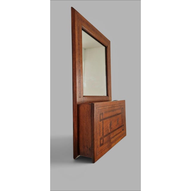 A rare wall mirror crafted from precious wood, adorned with linear and architectural marquetry, characteristic of late...