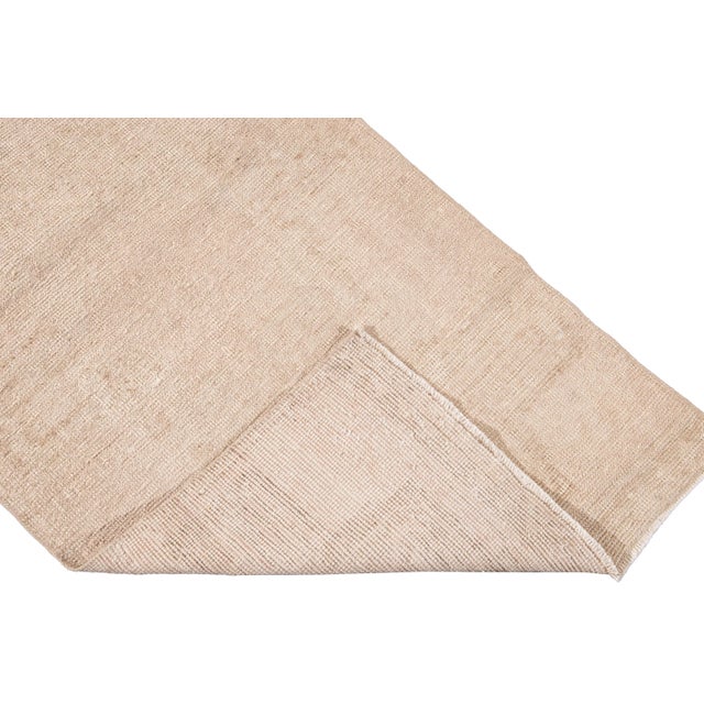 Beautiful vintage Turkish hand-knotted wool rug with a beige field. This rug has tan accents in a gorgeous all-over...