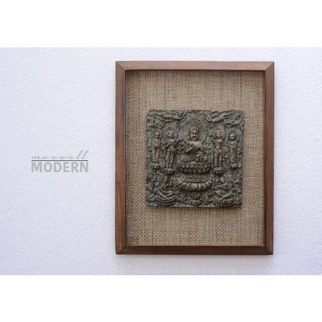 Stunning rare mid century era sculptural buddha wall art. Beautifully framed and mounted on a wicker rattan background....