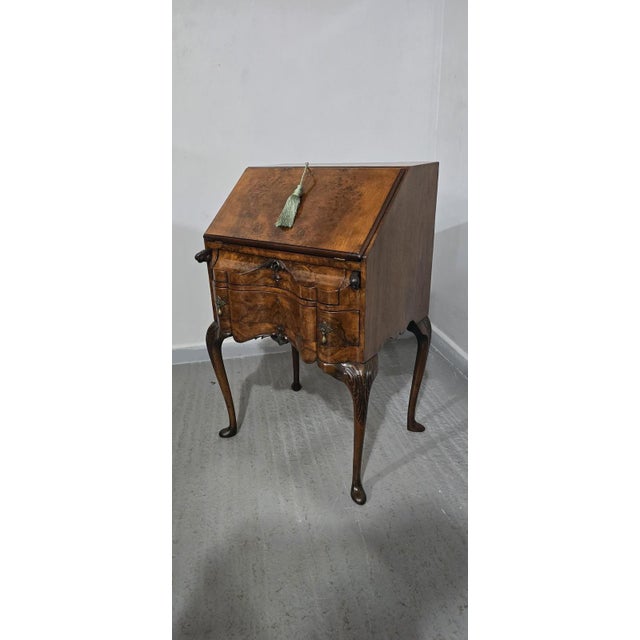 A very pretty Queen Anne serpentine fronted bureau of small proportions, standing on tall cabriole legs, eagle head...