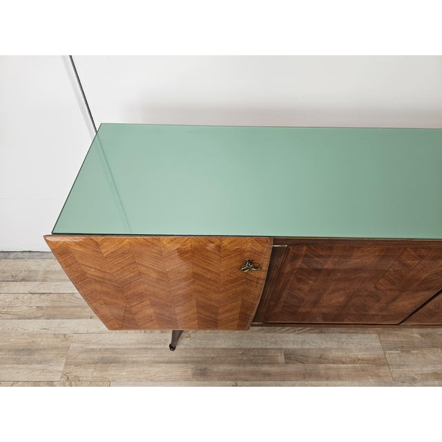 This 1960s-style sideboard features an elegant and sophisticated design, clad in fine mahogany burl that highlights the...