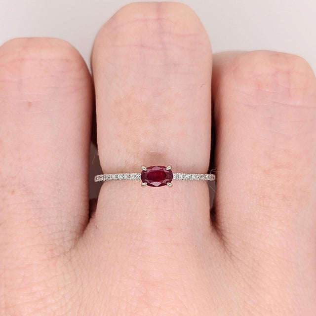 This beautiful ring features a sparkling east west prong set red ruby in 14k white gold with natural diamond accents. A...