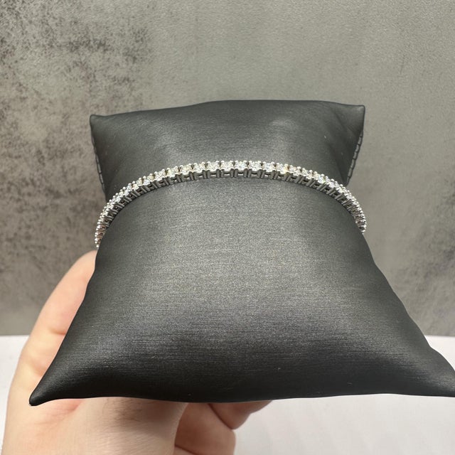 This stunning natural diamond tennis bracelet in 14kt white gold features 3.43 carats total weight of GH SI1–I1 round...