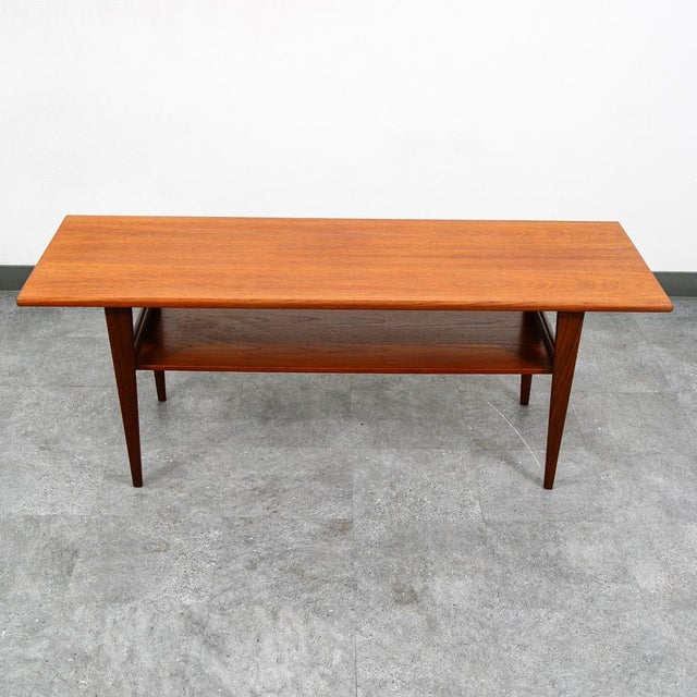 Solid teak danish modern surfboard coffee table. The solid teak and teak veneer top surface sits upon 4 solid teak tapered...