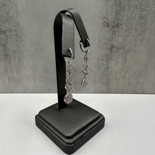 These stunning Diamond Multi Cluster Drop Earrings in 10kt white gold feature approximately 1.2ctw of natural HI SI2-I1...