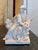 A blanc de chine white glazed ceramic figure depicting a seated musician holding a stringed instrument, accompanied by a...