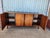 Mid-century modern sideboard is constructed from walnut wood with a dark wood finish. This piece has black top and four...