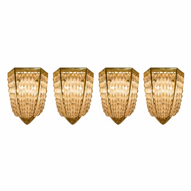 Four antique french deco wall lights in gilded bronze and crystal, 1920. A rare set of four art deco-style two-bulb wall...
