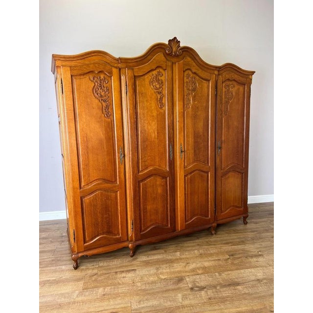 A striking Vintage French Louis wardrobe , crafted in oak and featuring an impressive four-door design with flowing shaped...