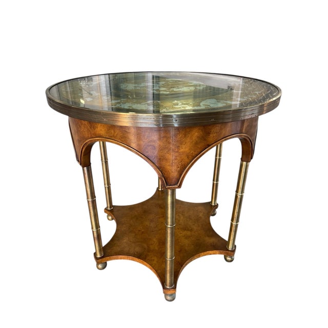 Elegant Early 20th Century accent table featuring a round reverse-painted eglomisé glass top with gold-leaf detailing and...