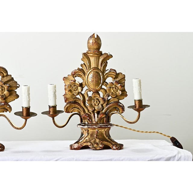 Dimensions: 17” H x 15 ½” W x 7 ½” D A French pair of double-arm giltwood candelabras from the 1700s. These impressive,...
