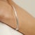 A refined expression of minimalist elegance, this sterling silver bangle bracelet features 3.53 carats total weight of...