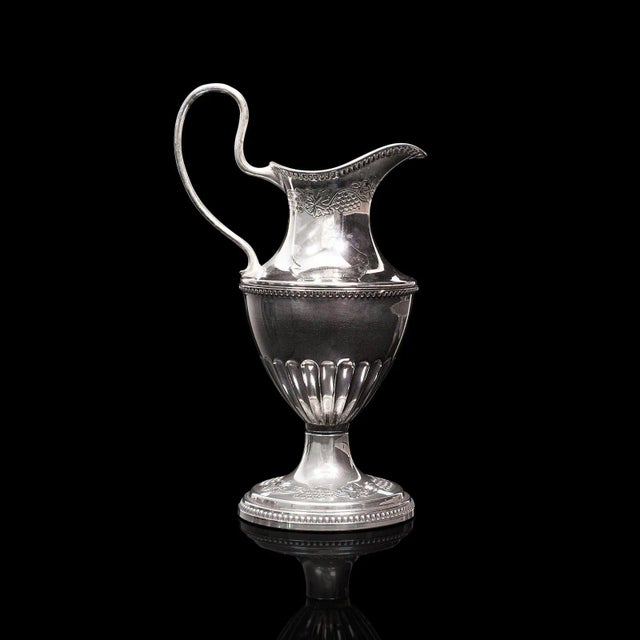 This is a small antique pouring jug. An English, silver plate decorative posy vase, dating to the Edwardian period, circa...