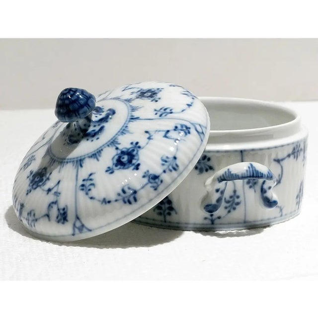 Indulge in the exquisite beauty of Royal Copenhagen's Blue Fluted Plain covered sugar bowl – a masterpiece from the iconic...