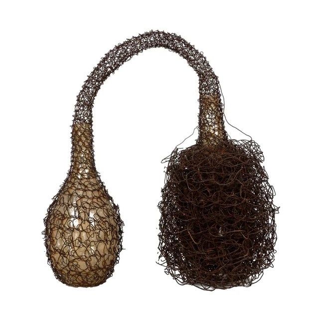 A sculpture of two glass bottles joined by woven wire by critically acclaimed contemporary sculptor and installation...