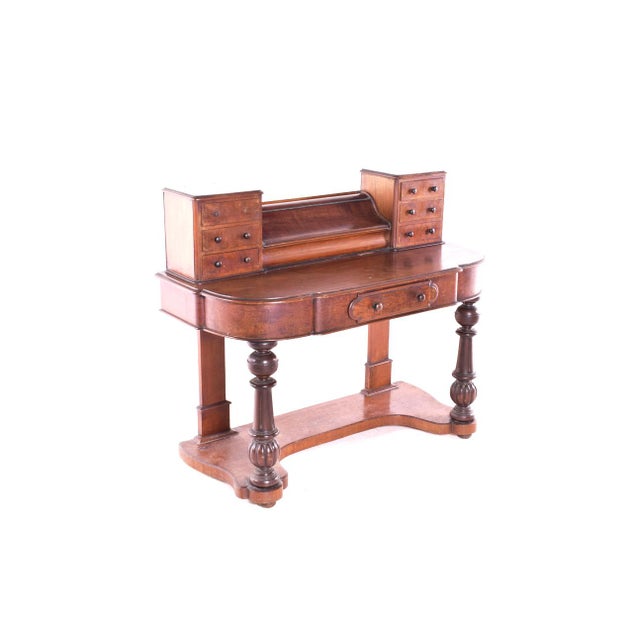 Beautiful antique walnut desk with a central compartment with rolled lid, flanked by six small drawers on top. Standing on...
