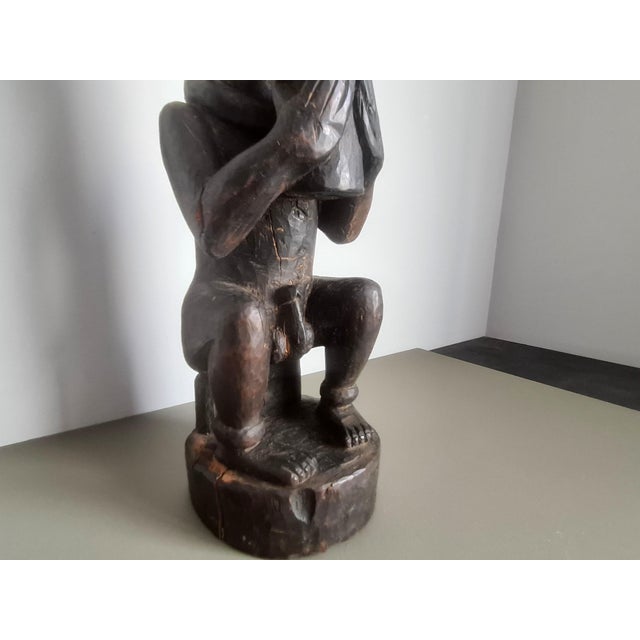 Superb antique carved wooden sculpture depicting a seated, horned figure holding a vessel. Origin: West Africa (Inspired...