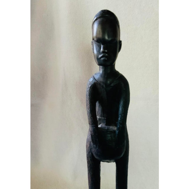 Exude curated, global sophistication with this striking mid-century hand-carved ebony wood sculpture depicting a...